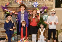 a group of children standing next to each other in front of a table filled with candy