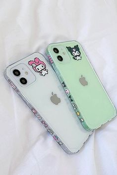 two iphone cases with hello kitty stickers on them sitting next to each other in front of a white sheet