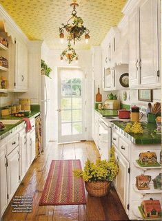 an open kitchen with white cabinets and green counter tops, along with a rug on the floor