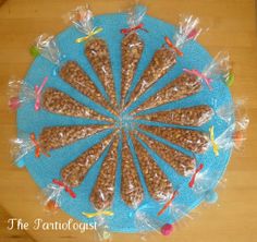 a blue plate topped with lots of food on top of a wooden table covered in plastic wrap