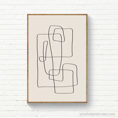 a black and white abstract line drawing on a wall above a wooden framed art print