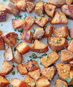 roasted potatoes with herbs and seasoning on a baking sheet