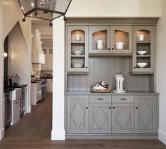 a kitchen with gray cabinets and white walls