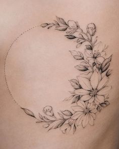 a woman's stomach with flowers and leaves on it, in the shape of a crescent