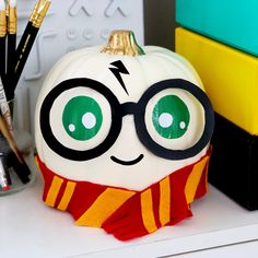 a harry potter pumpkin sitting on top of a desk next to markers and pencils