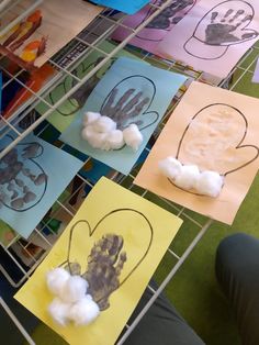 several handprints are placed on paper with clouds in the shape of hearts and hands