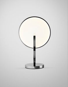 an illuminated table lamp sitting on top of a metal stand