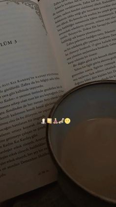 an open book with stickers on it next to a frying pan and spoon