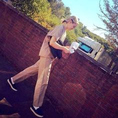 a person walking past a brick wall with a microwave on it's back end