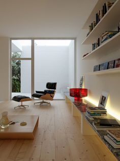 a living room filled with furniture and bookshelves next to a large glass window