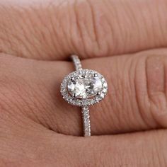 a close up of a person's hand with a diamond ring on their finger