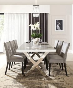 a dining room table with grey chairs around it