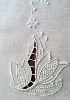 a close up of a piece of cloth with embroidered designs on it and beads hanging from the side