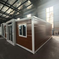 the inside of a building with windows and doors on each side is brown and white