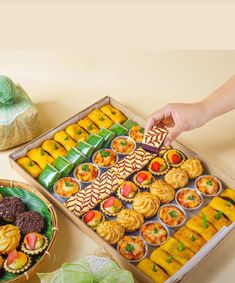 a box filled with assorted pastries next to other foods on top of a table