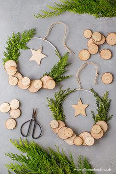 christmas wreaths made out of wood with scissors and pine branches on the table next to them