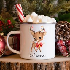 a white mug filled with marshmallows and topped with a reindeer on it