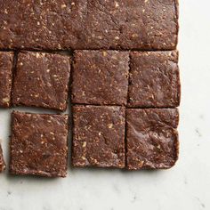 brownies cut into squares on top of a white counter with some nuts in the middle