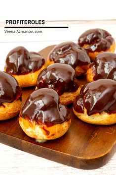 chocolate covered donuts sitting on top of a wooden cutting board