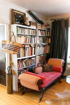 a living room filled with lots of books and furniture