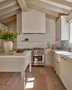 a kitchen with an oven, stove and counter tops in white painted wood flooring