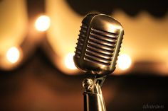 an old fashioned microphone with lights in the background