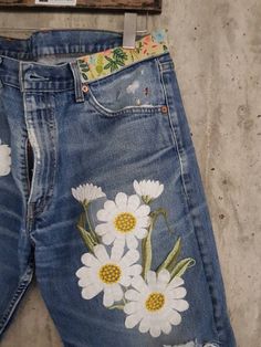 a pair of jeans with flowers painted on them