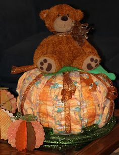 a teddy bear sitting on top of a pumpkin