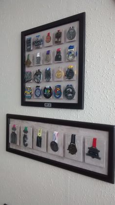 two framed pictures on the wall with different badges and pins in them, one has a black frame