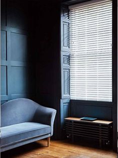 a blue couch sitting in front of a window