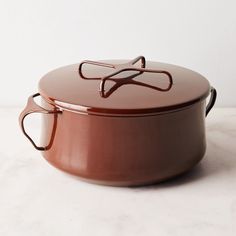 a brown pot with handles on a white table