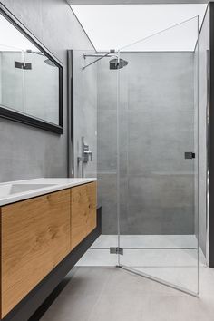 a bathroom with a sink, mirror and shower stall in the middle of the room