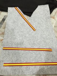 two pieces of felt are laid out on the floor next to each other, with yellow and red pencils sticking out of them