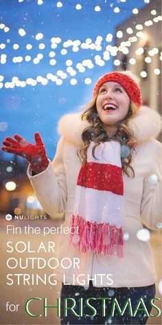 a woman wearing a red and white scarf standing in the snow with her hands out