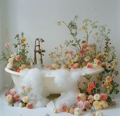 a bathtub filled with cotton and flowers