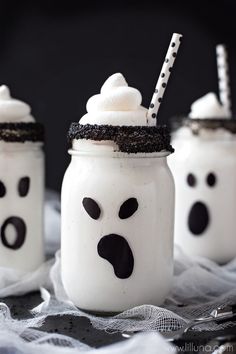 three mason jars with marshmallows and faces painted on them, sitting on a table