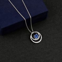 Product Details If you want to fortify your relationship and make it enduring, consider our Created Blue Sapphire Pendant Necklace as the ideal option. The necklace boasts a 6 MM Round Cut Created Blue Sapphire securely held in a Prong Setting and encircled by dazzling Round Moissanite on an open circle pendant. Product Information SKU SHP-PENDANT032214587 Weight 2.40 gm (Approximate) LAB CREATED BLUE SAPPHIRE INFORMATION No.of Stones 1 Pieces Total Weight 1.05 Carat (Approximate) Dimension(appr Blue Tanzanite Necklace With Brilliant Cut, Sapphire Color Lab-created Sapphire Necklace For Anniversary, Anniversary Sapphire Necklace With Lab-created Sapphire, Anniversary Sapphire Necklace With Lab-created Gem, Blue Necklaces With Halo Setting For Anniversary, Blue Tanzanite Jewelry With Halo Design, Tanzanite Round Necklaces For Anniversary, Blue Necklace With Halo Setting For Anniversary, Blue Lab-created Sapphire Necklace For Anniversary