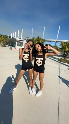 two young women in black shirts posing for a photo with their arms around each other