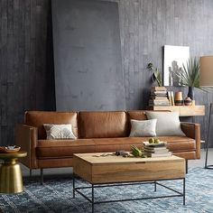 a living room filled with furniture next to two large paintings on the wall above them