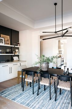 a dining room table with chairs and a potted plant sitting on top of it