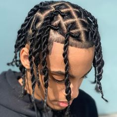 a man with long dreadlocks wearing a black hoodie and looking down at his phone