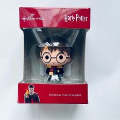 a harry potter christmas tree ornament is in the box with its own figure