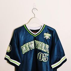 a new york baseball jersey hangs on a hanger in front of a white wall