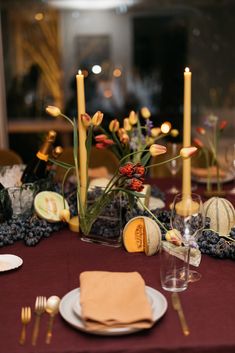 the table is set with candles, plates and napkins for an elegant dinner party