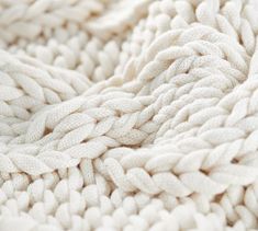 close up view of white knitted fabric with braiding on the bottom and sides