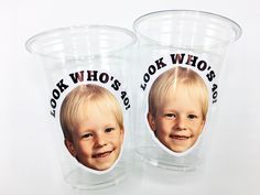 two plastic cups with pictures of children's faces on them