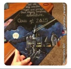 someone is holding up a graduation cap with the words class of 2015 on it and an image of a castle at night