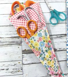 some scissors are laying on top of a flowered umbrella with gingham fabric