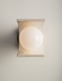 a light that is on the side of a wall with a white ball in it