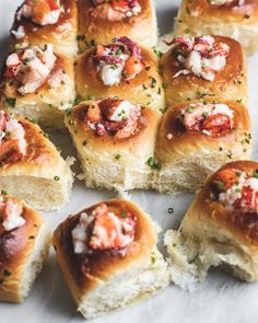 several rolls with meat and cheese on them sitting on a plate next to some garnish